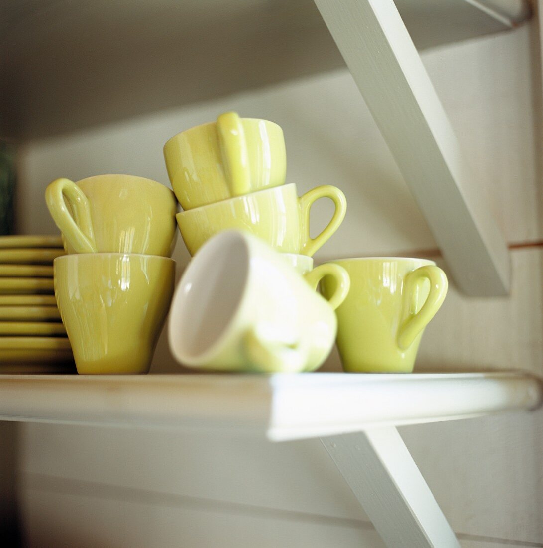 Yellow espresso cups on a shelf