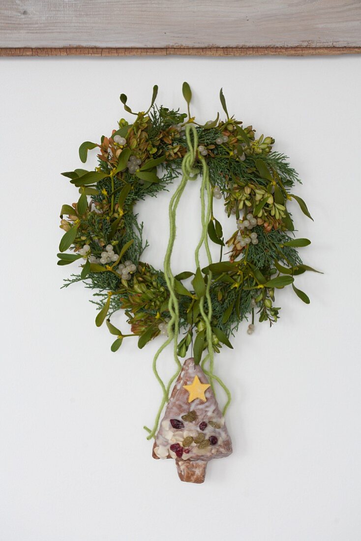 Wreath of mistletoe, box and conifer with Christmas tree cake