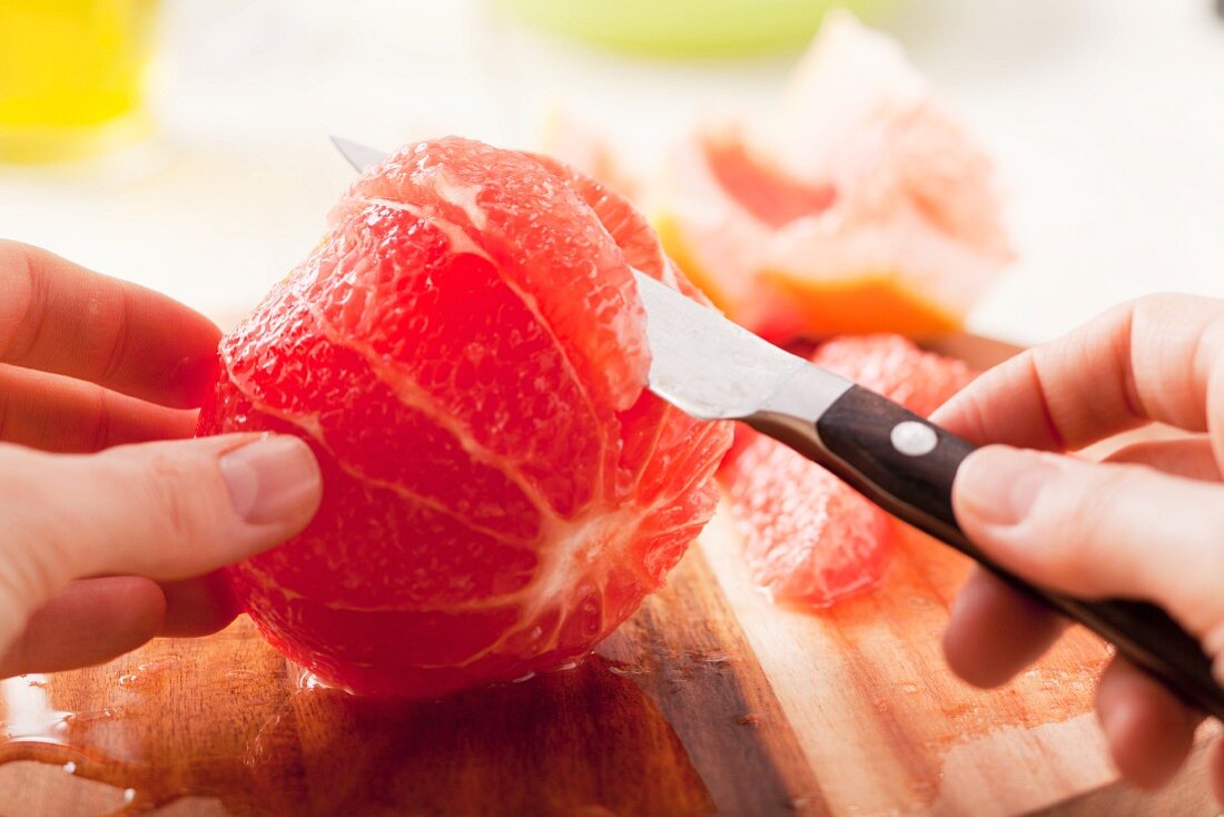 A grapefruit being filleted