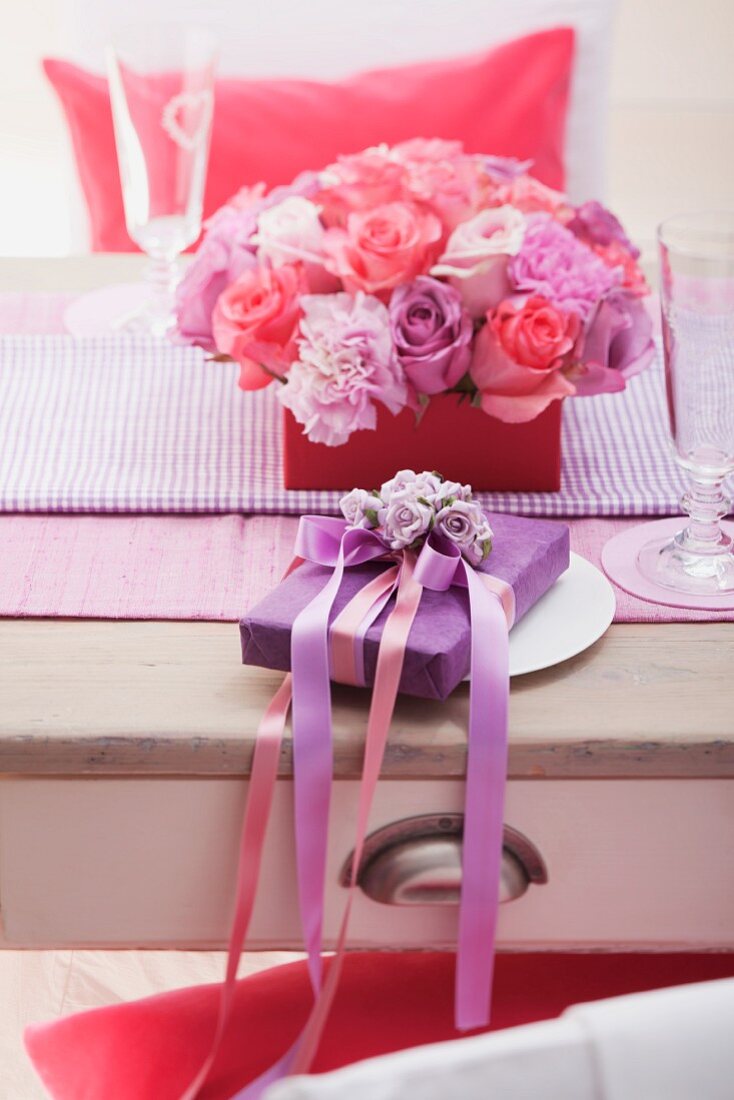 Tisch mit Blumengesteck und Geschenk