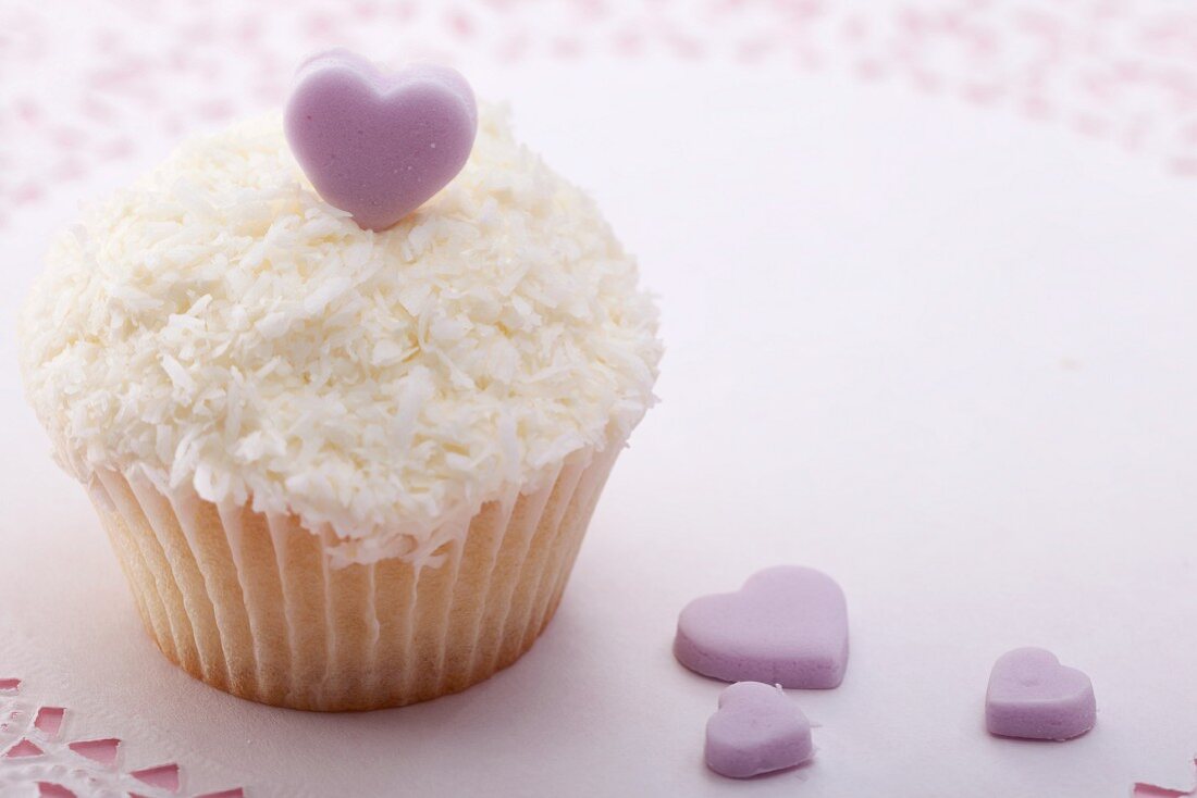 Cupcake with grated coconut and sugar heart