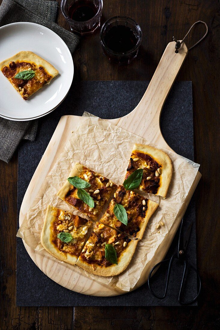 Pizza mit Kürbis, Feta und Basilikum, in Stücke geschnitten