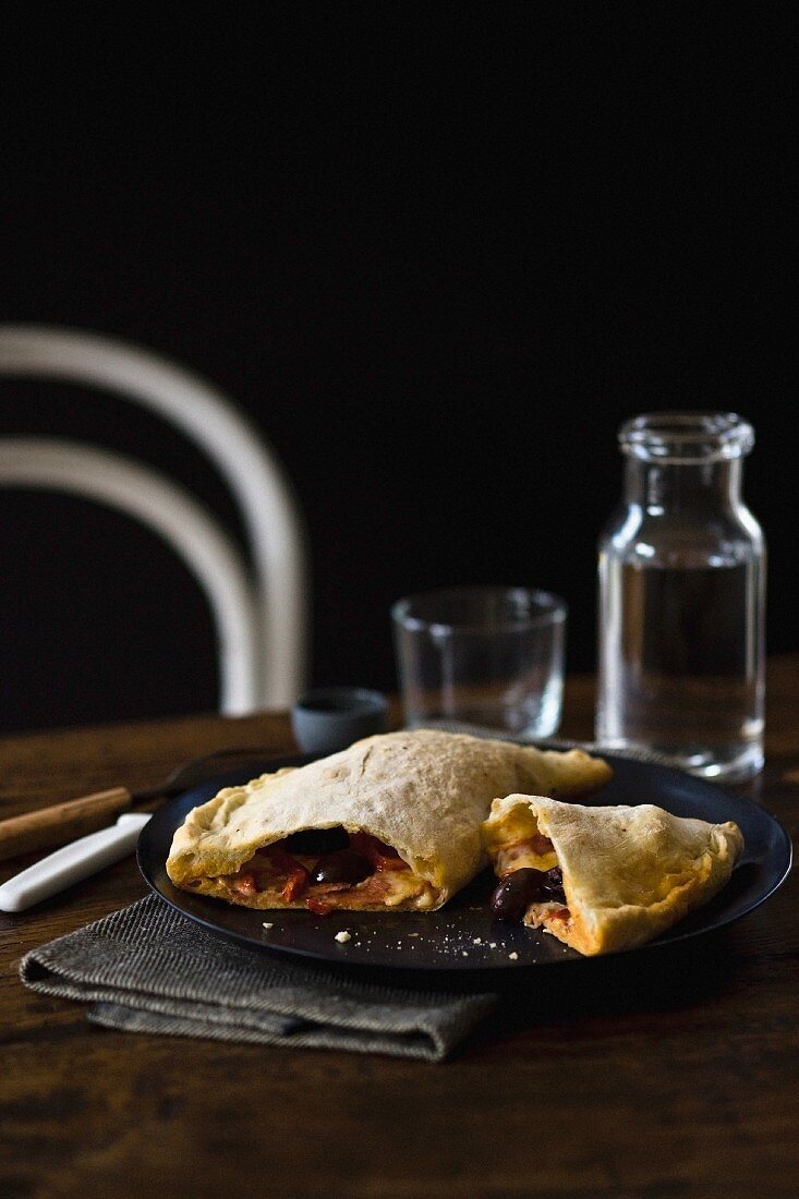 Calzone mit Salami, Oliven und Pfefferoni