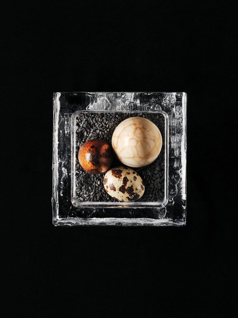 Wachtelei und marmoriertes Ei auf gerösteten schwarzen Sesamsamen