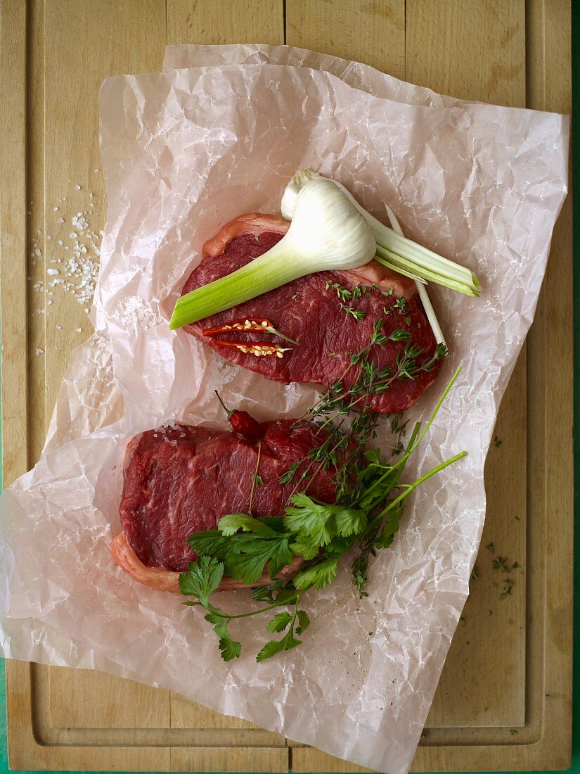 Raw beef steaks with garlic and herbs