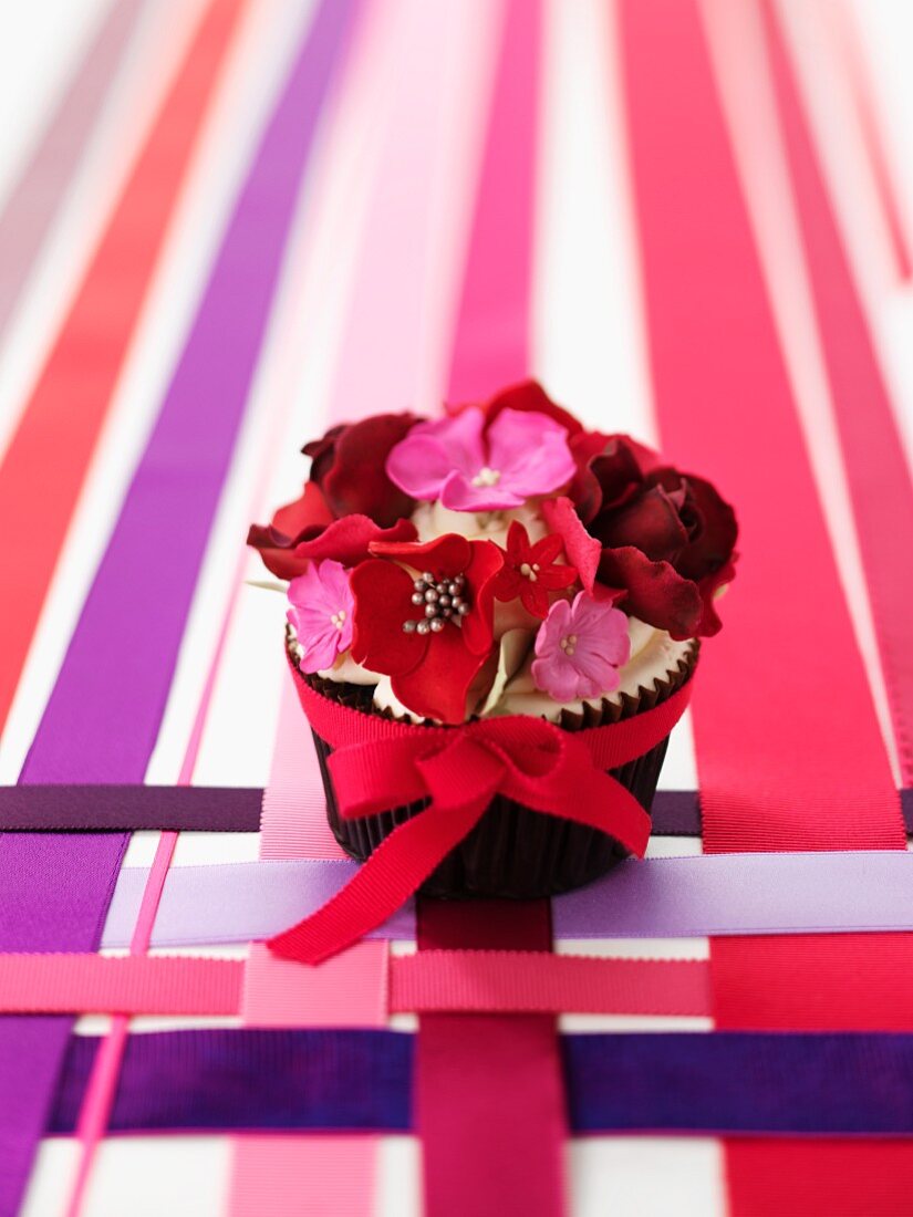 Hochzeits-Cupcake mit Blumen und Schleife