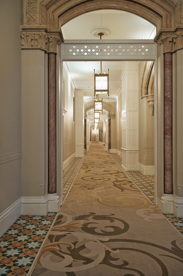 Runner with ornamental pattern and lantern ceiling lamps in hallway of Baroque villa