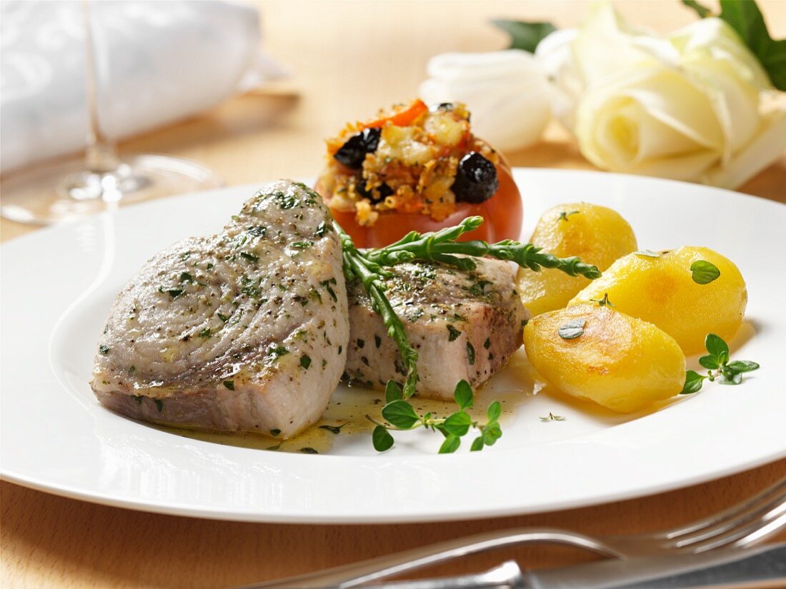 Schwertfischsteaks mit Bratkartoffeln und gefüllter Tomate