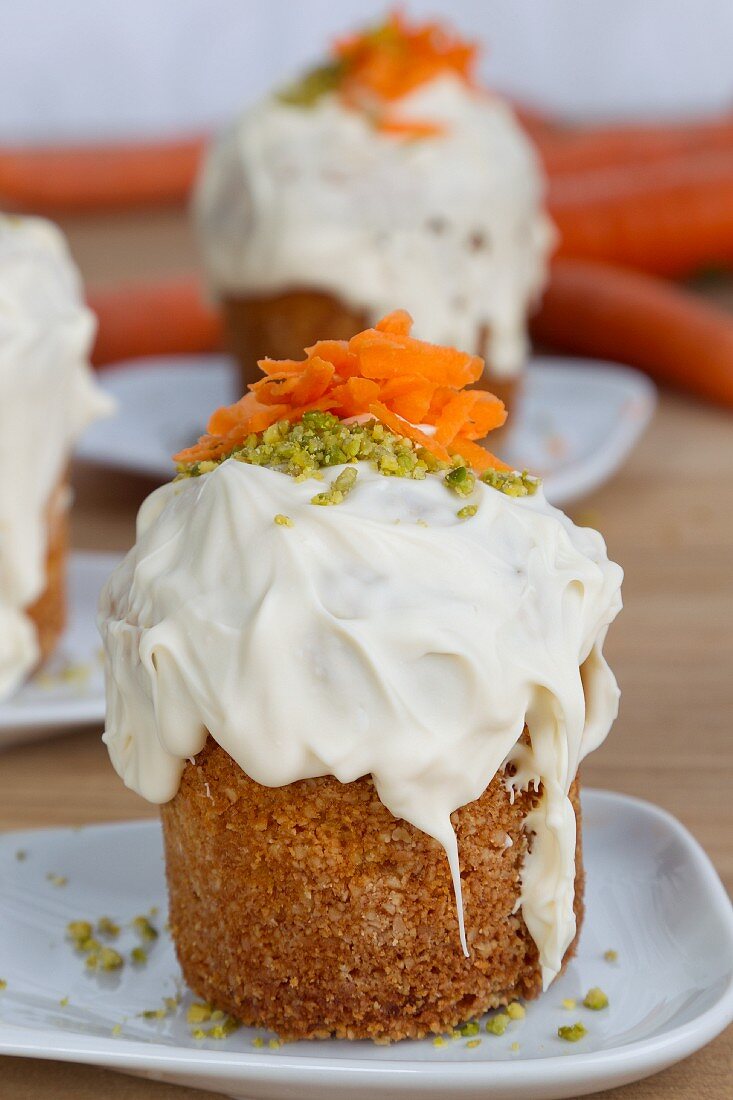 Kleine Möhrenkuchen mit Zuckerguss und Pistazien