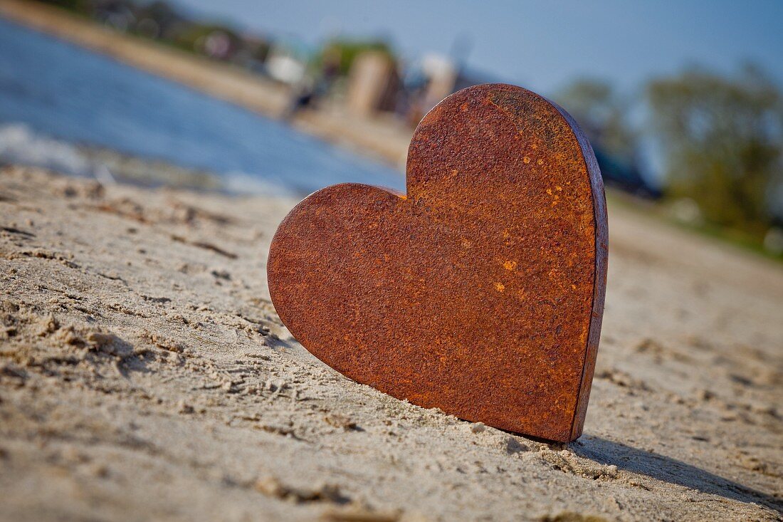 Rostiges Metallherz am Sandstrand