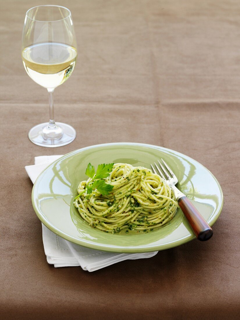 Spaghetti with parsley pesto, white wine glass