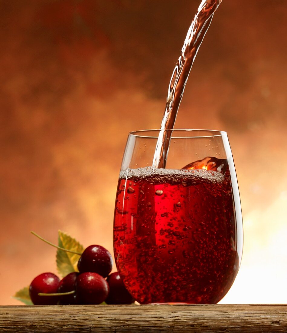 Pouring cherry juice into a glass