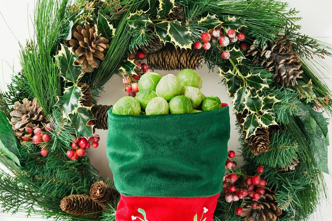Brussels sprouts in a stocking in front of a Christmas wreath