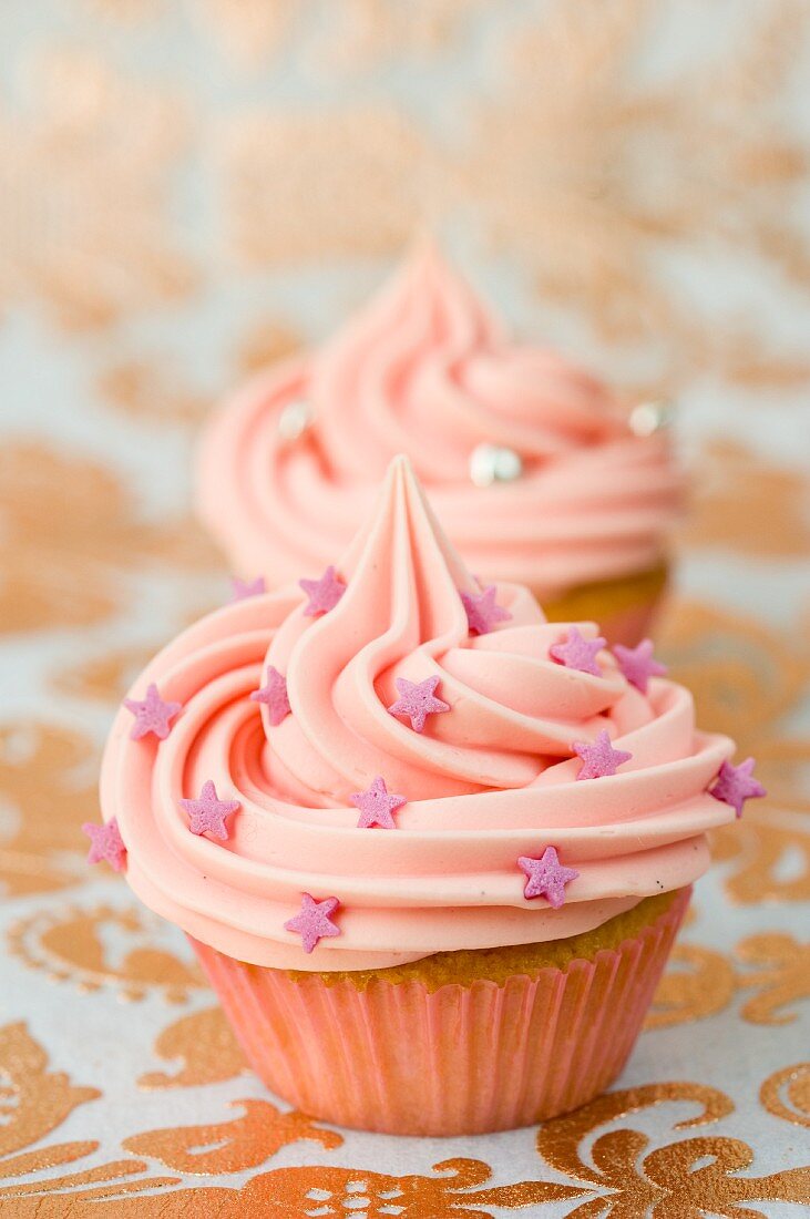 Pink cupcakes with sugar stars and silver pearls