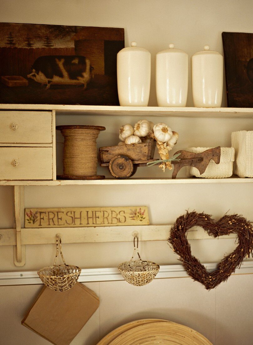 Vintage kitchen shelves with white ceramic storage jars and heart-shaped wicker wreath