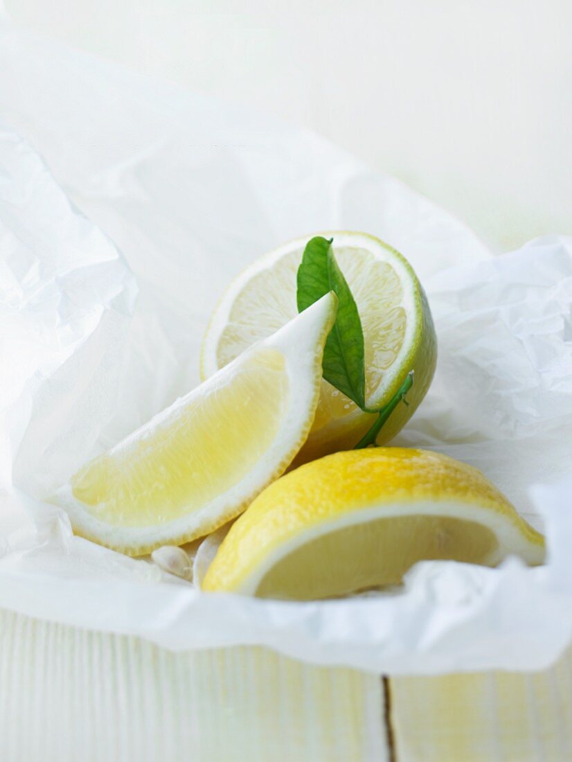 Halbe Zitrone und Zitronenschnitze auf Papier