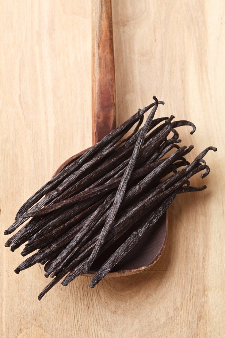 Bourbon and vanilla pods on an old wooden cooking spoon