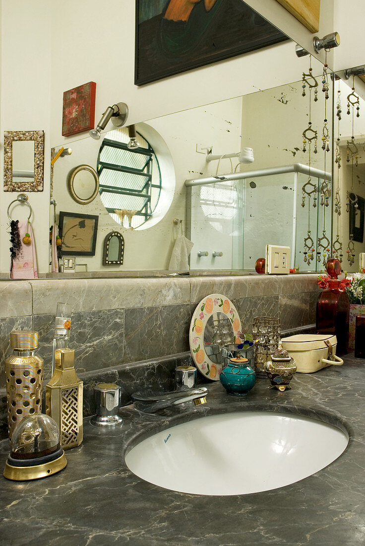 Large wall-mounted mirror above marble washstand in bathroom