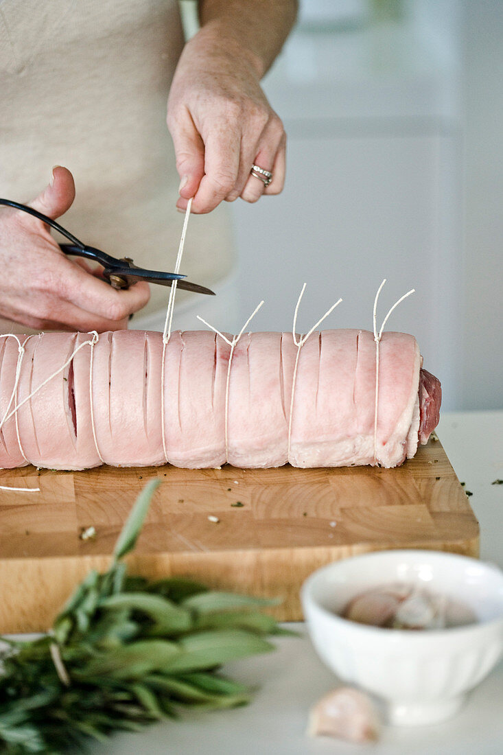 Making rolled pork roast with garlic and sage