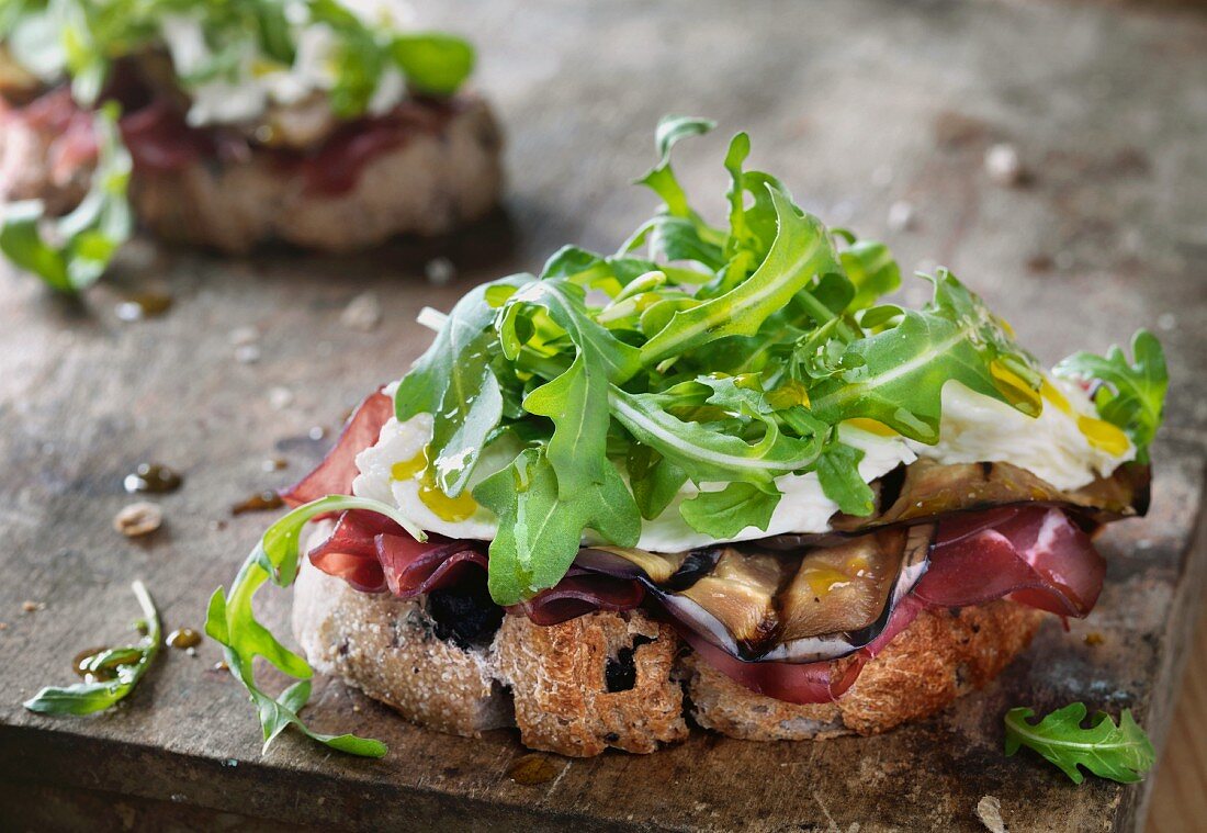 Open-faced sandwiches with ham, grilled aubergine, cheese and rocket