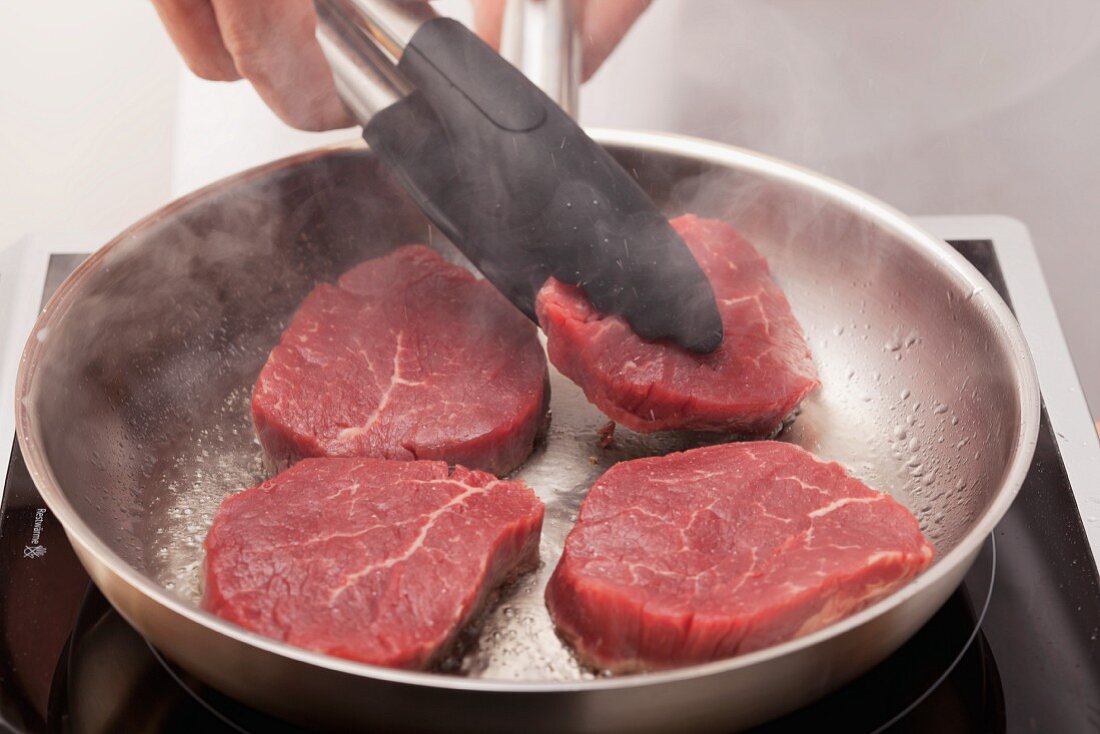 Frying steaks in a pan