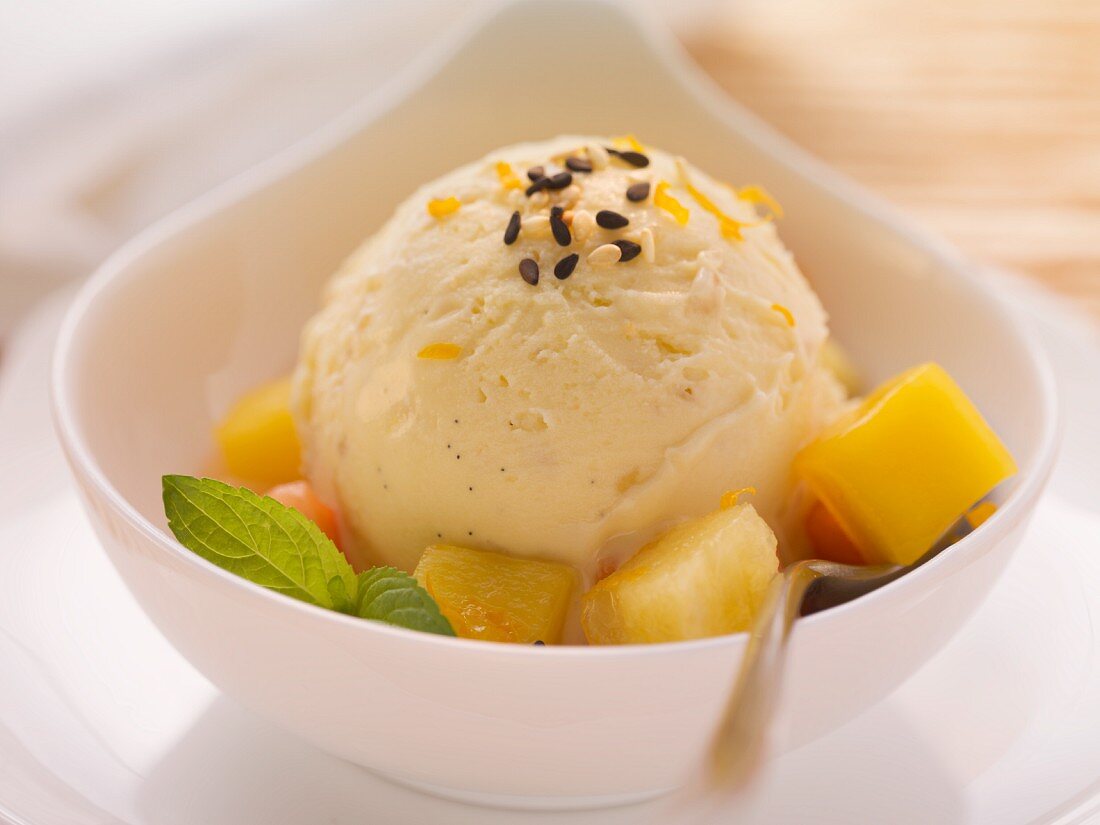Vanilla and sesame ice cream garnished with ginger and fruit salad