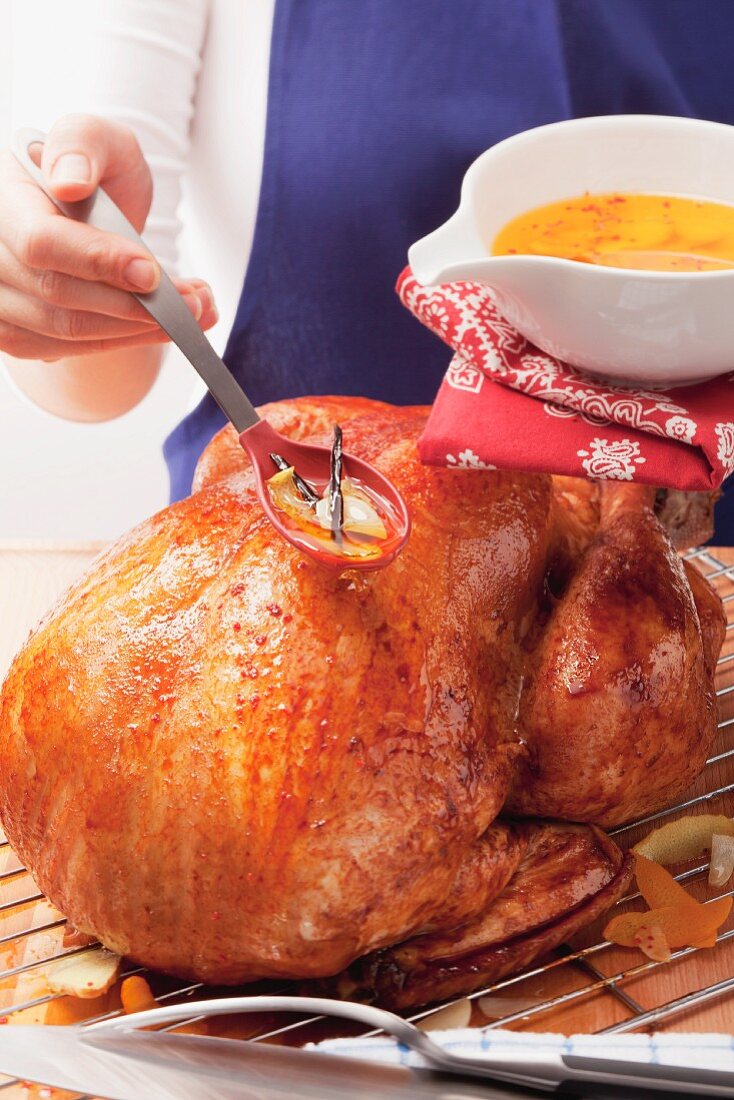 Basting roast turkey with lemon marinade