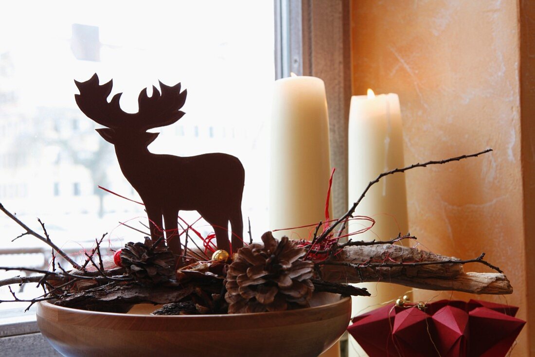 Weihnachtliche Hirschfigur auf Kiefernzapfen und Holz