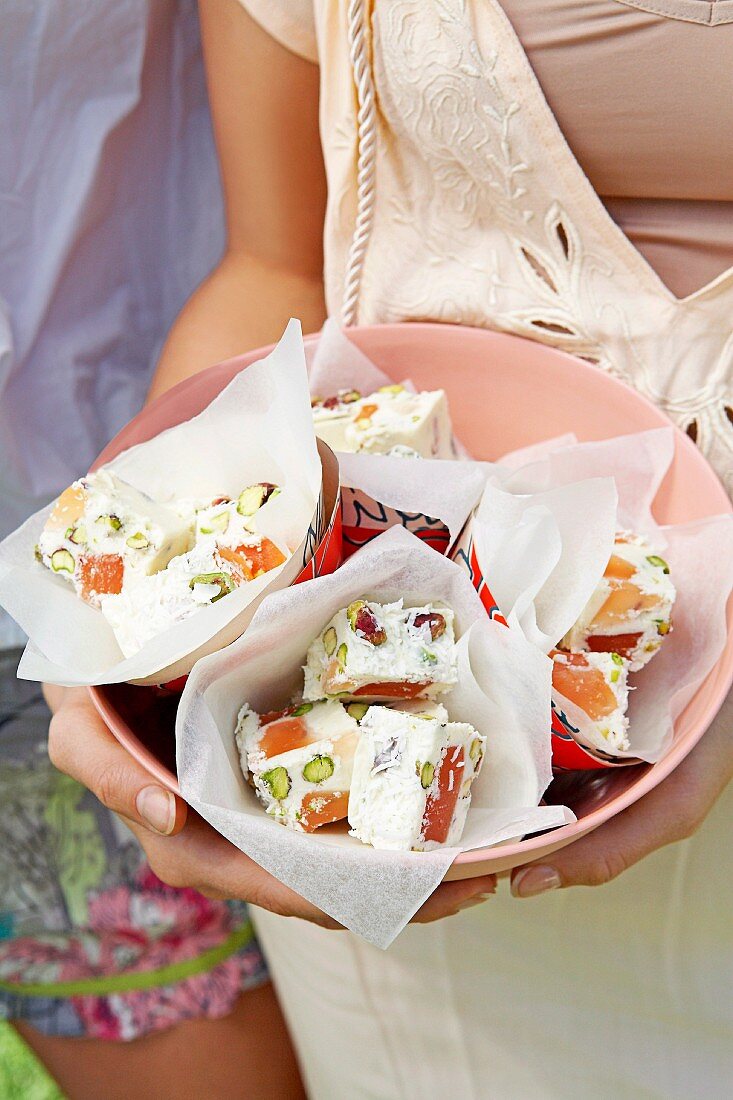 A woman holding a bowl of Rocky Road slices