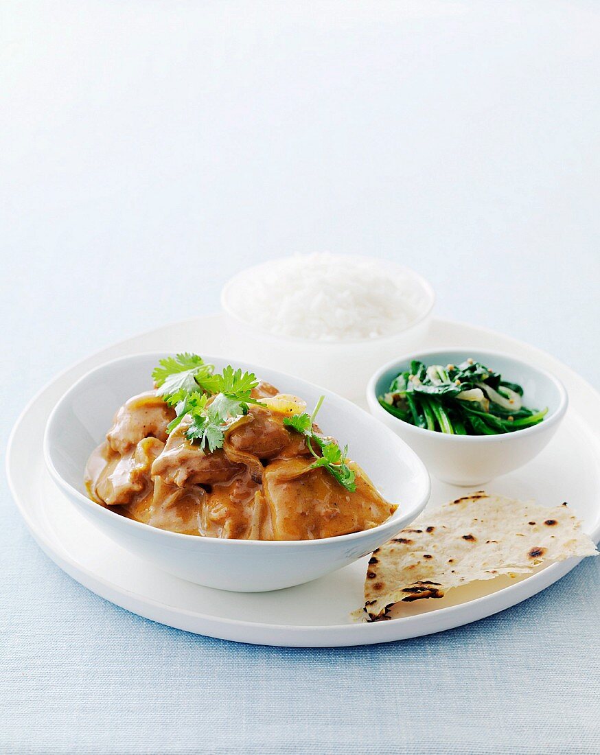 Butter chicken in mustard sauce with spinach, rice and flatbread