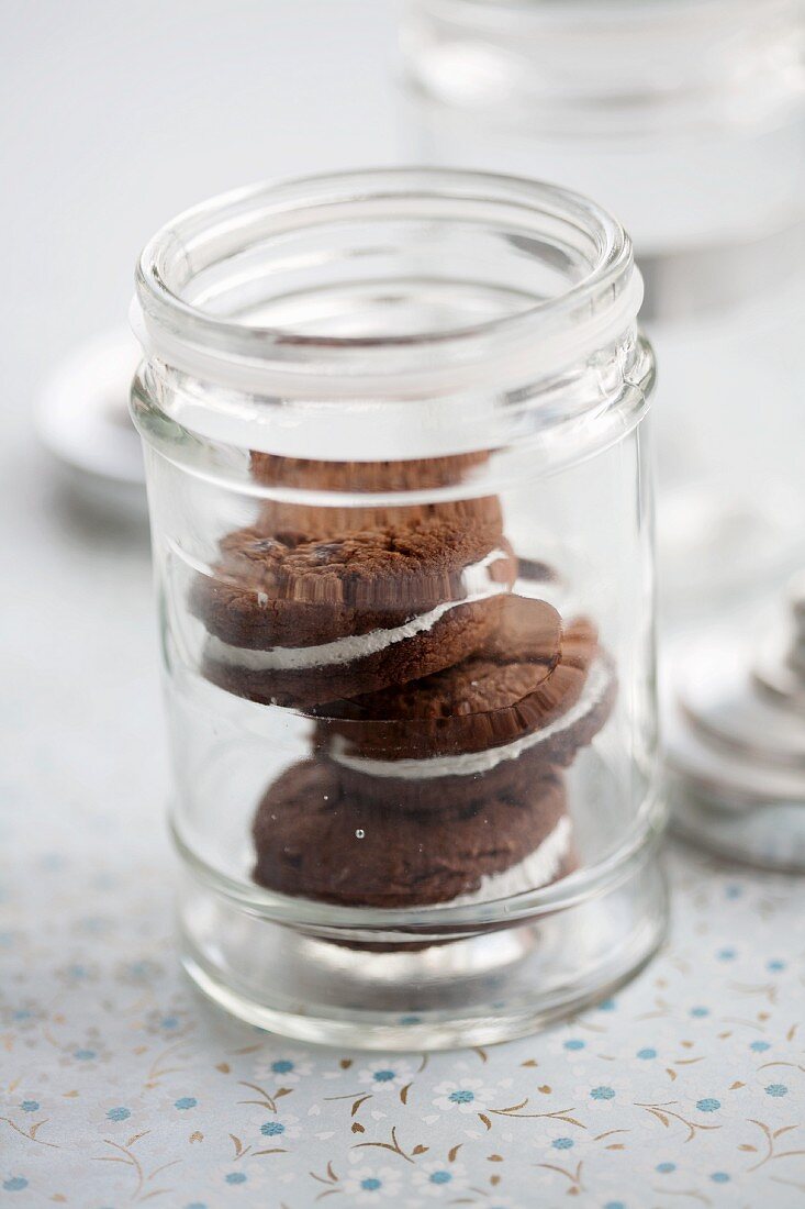 Drei Schokoladen-Whoopie Pies, gestapelt in Glasgefäß