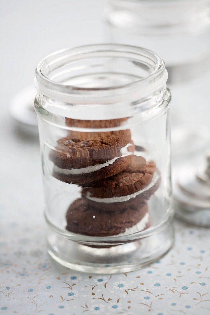 Three chocolate whoopie pies stacked in a glass jar