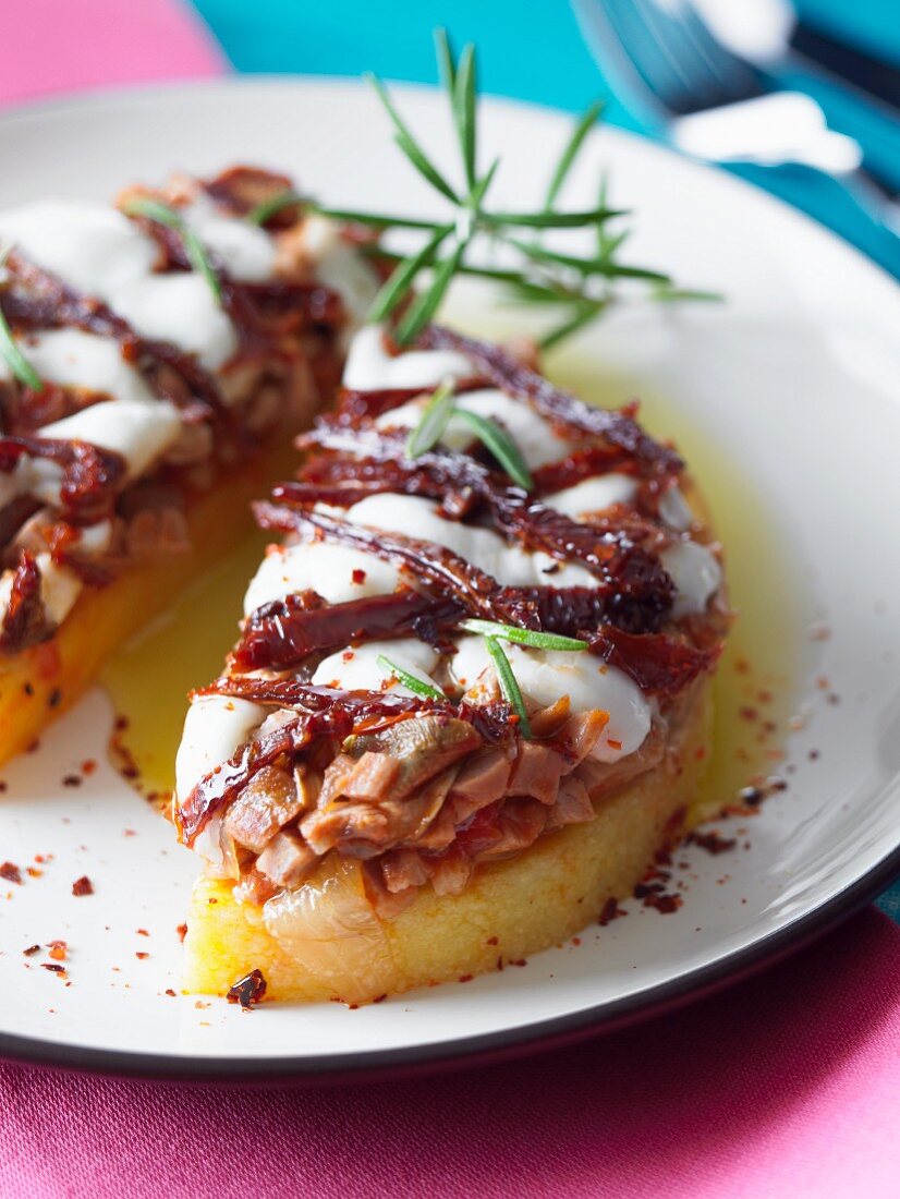 Polenta slices topped with veal and dried tomatoes