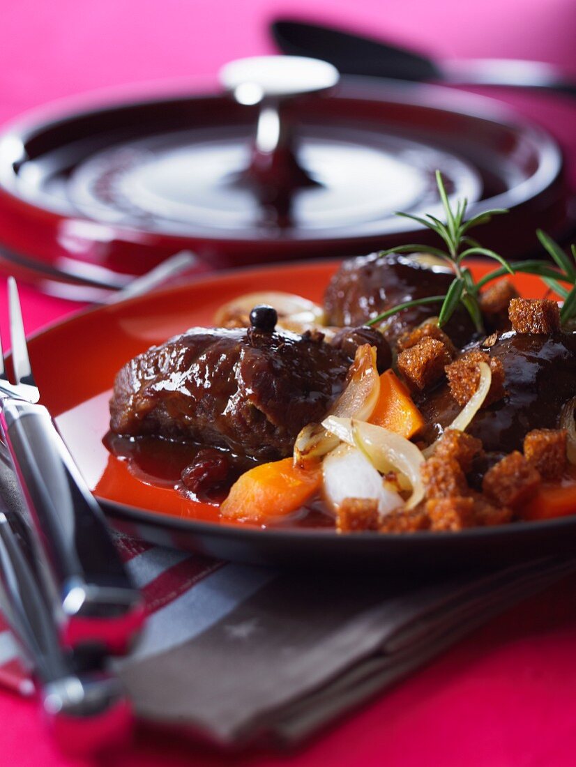 Pork cheek in beer sauce with carrots and croutons