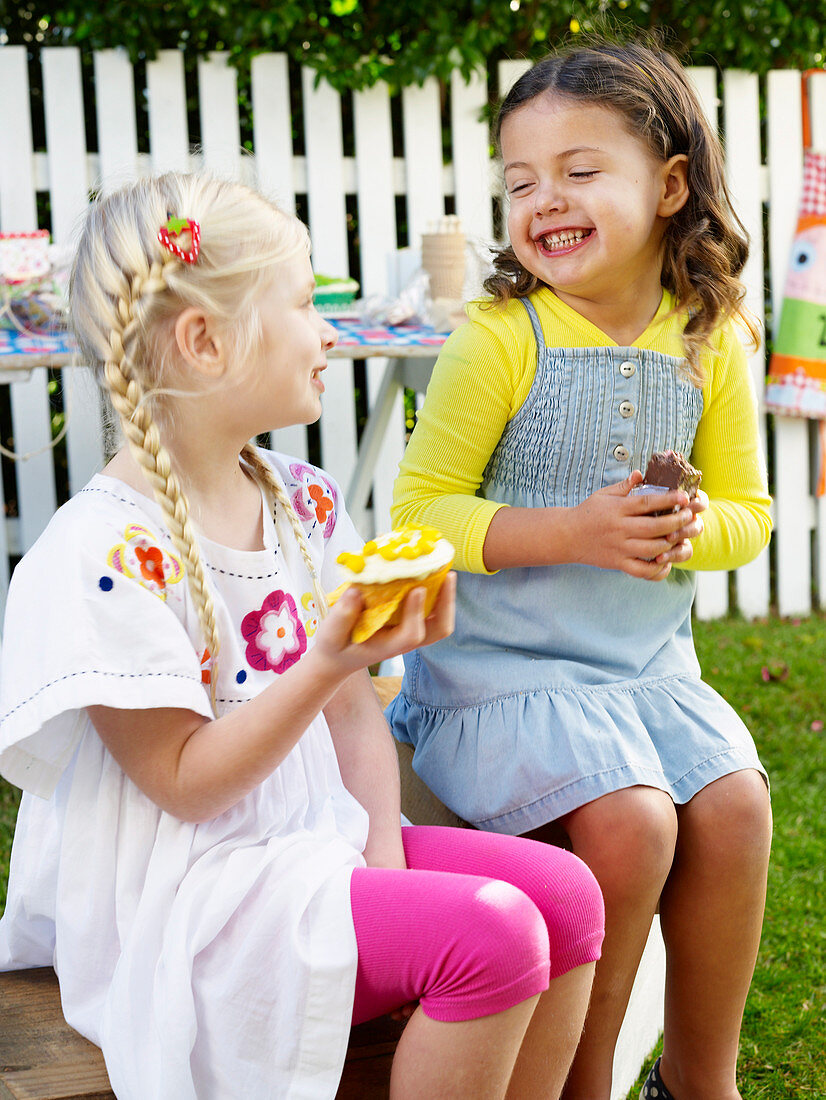 Two girls eating sweets at a school fete