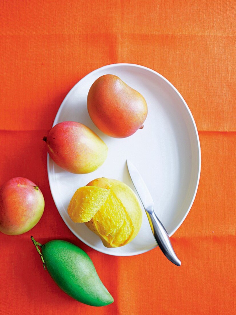Fresh mangos, one peeled