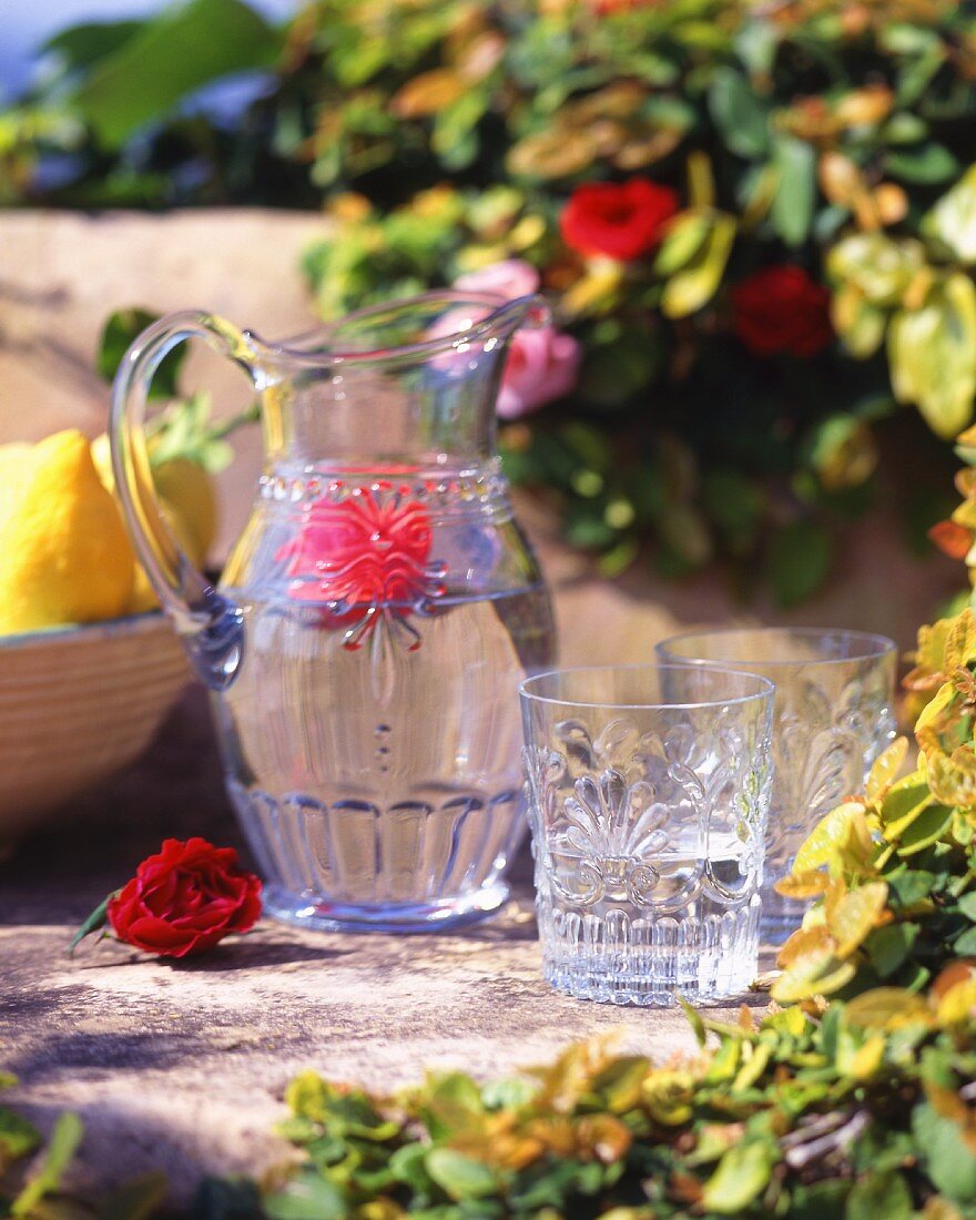 Jug of water with flower and water glasses