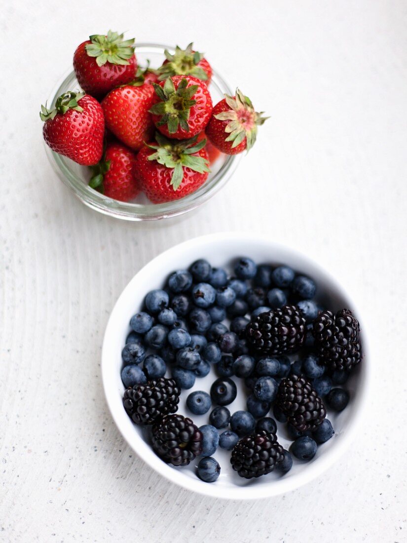 Strawberries, blueberries and blackberries in bowls