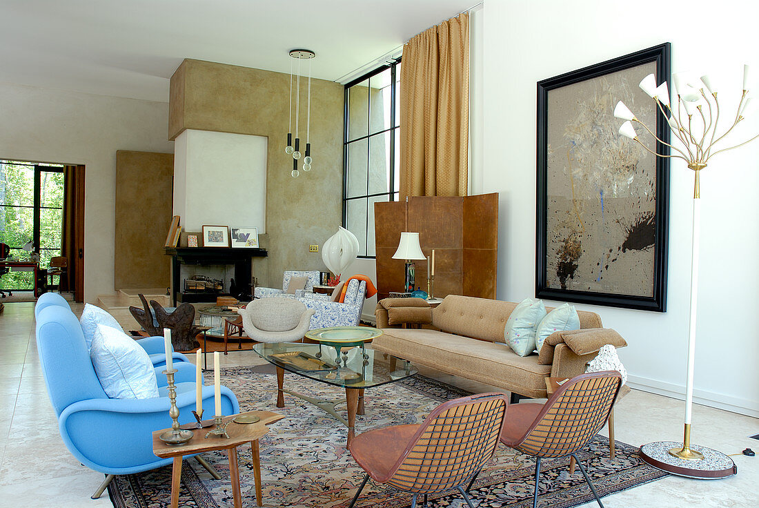 Eclectic collection of chairs and multi-armed standard lamp in spacious living room of classic modern house