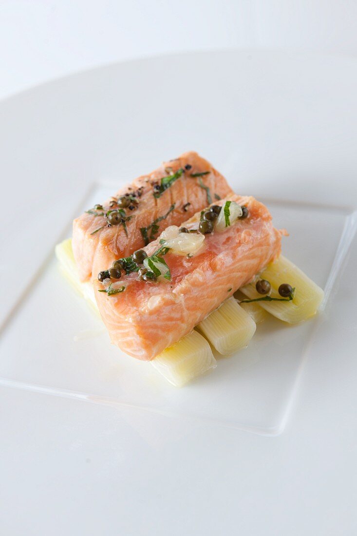 Salmon fillet with capers and lemons on a bed of leek