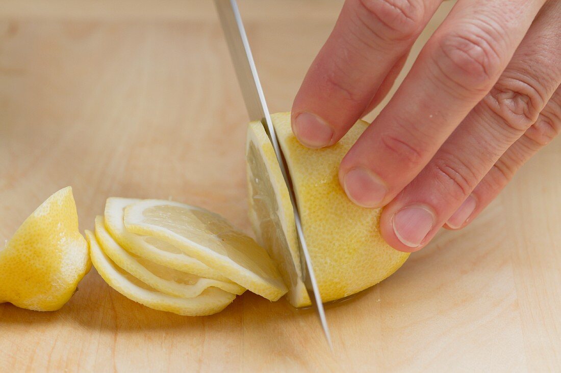 Zitrone in dünnen Scheiben schneiden