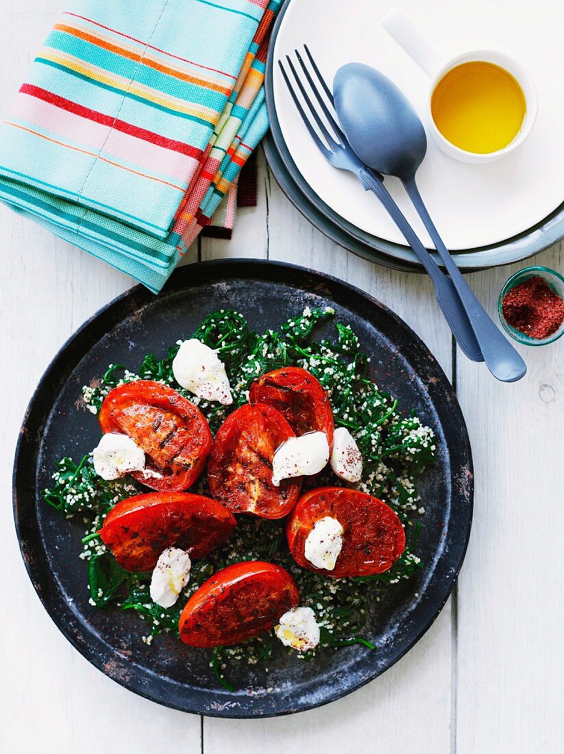 Grilled tomatoes with labneh on spinach-bulgur
