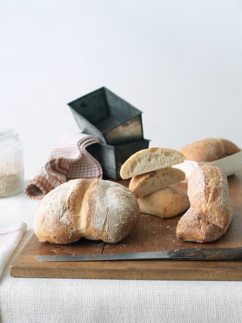 Assorted Artisan Breads on a Cutting Board with Pans