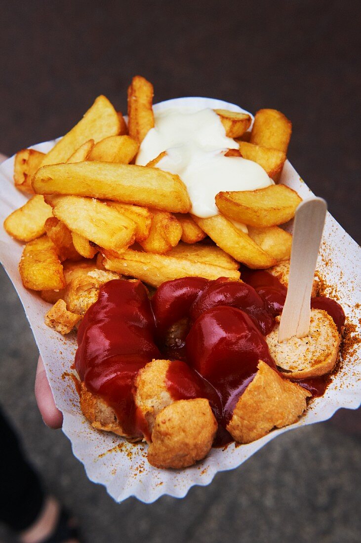 Curried sausage with chips, ketchup and mayonnaise