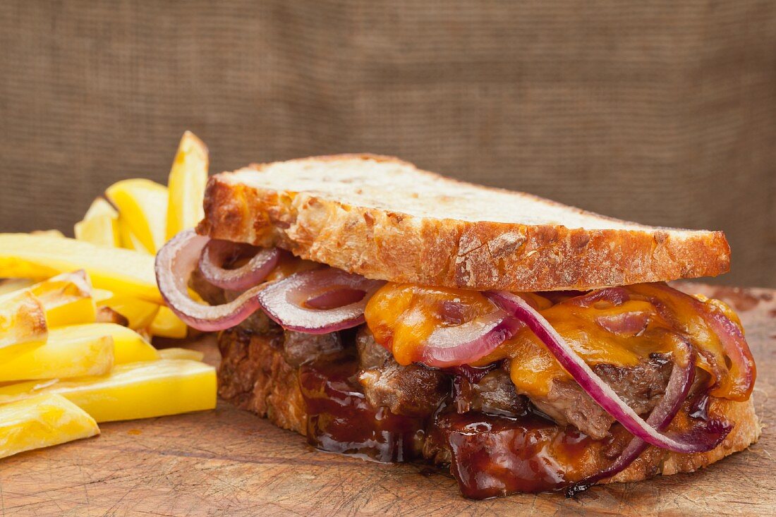 Steak sandwich with cheddar, onions and BBQ sauce