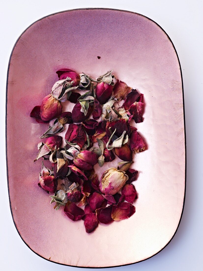 Dried rose petals in a bowl (top view)