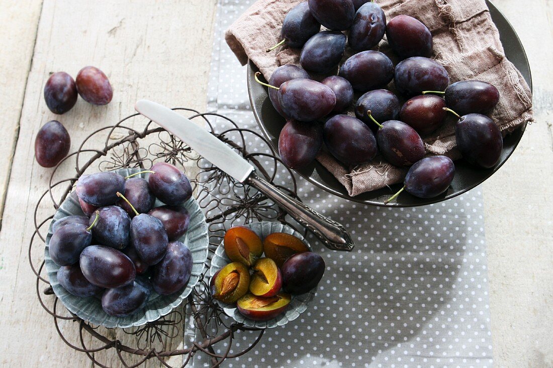 A bowl of fresh plums on spotted cloth