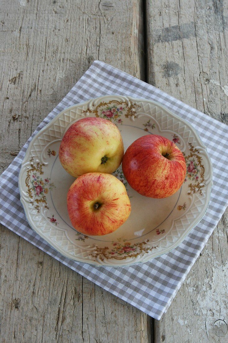 Drei Äpfel auf Vintage-Teller