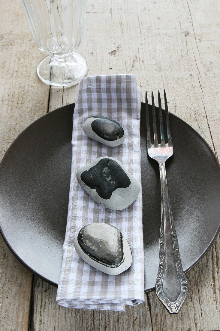 Teller mit Serviette und lackierten Steinen