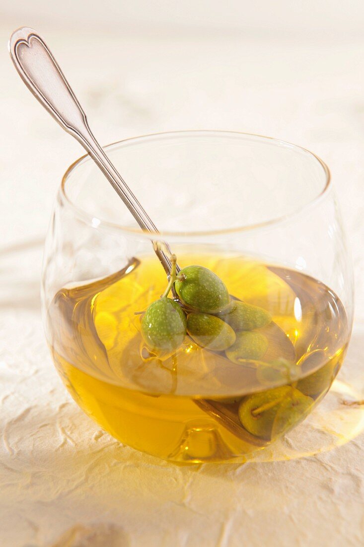 Glass with olives and olive oil